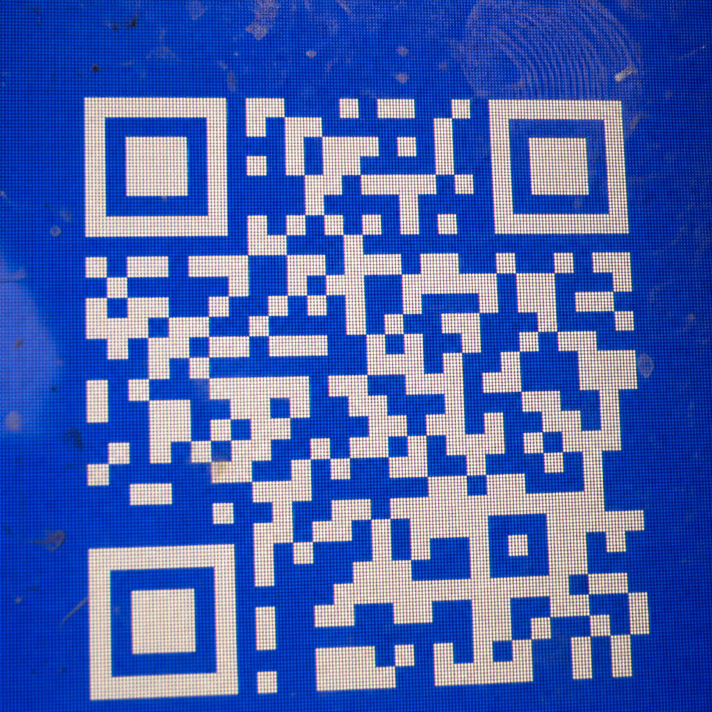 Macro photo of a Blue Screen QR code on a dusty monitor.